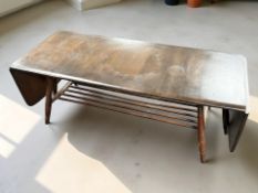 An Ercol stained elm drop leaf coffee table, with undershelf, extended 160 cm x 46 cm x 36 cm.