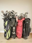 Four golf bags containing assorted irons and drivers including Dunlop,