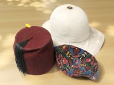 A fez, a pith helmet and a further eastern hat.