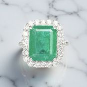 An 18ct white gold emerald and diamond cluster ring,