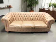A Chesterfield style buttoned tan leather three seater settee,