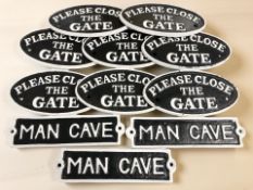 A group of reproduction painted cast iron signs and plaques including 'Please close the gate' and