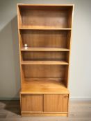 A Scandinavian teak open bookcase with sliding doors beneath,