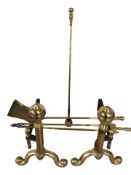 A pair of brass fire dogs and a three piece companion set.