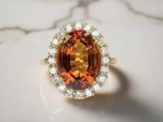 An 18ct gold golden citrine cluster ring, the large faceted-oval citrine weighing an estimated 7.