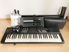 A Rockjam RJ5061 digital keyboard, on stand with a stool, a pair of headphones and music books.