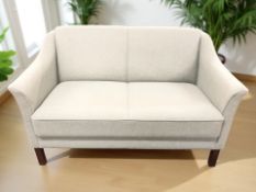 A contemporary Scandinavian two seater settee in pale green fabric,