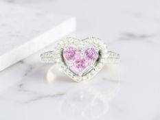 A pink topaz and diamond ring, the three faceted topaz forming a central heart motif,