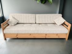 A Scandinavian pine framed settee/day bed in checked fabric,