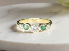 An 18ct gold emerald and diamond five-stone ring, size N CONDITION REPORT: 3.