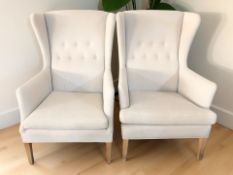 A pair of Scandinavian wing back armchairs in cream fabric