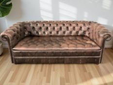 A Chesterfield style buttoned brown leather three seater settee,