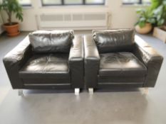 A pair of Scandinavian black leather lounge armchairs on chrome feet,