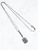 An 18ct white gold blue topaz and diamond pendant on chain.