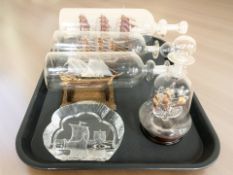 Four glass ships in bottles and a glass paperweight depicting Viking longships.
