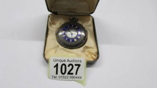 A small monogrammed silver pocket watch.