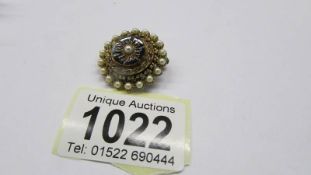 A circular mourning brooch set seed pearls.