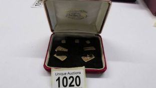 A pair of gold cuff links with three matching studs in original box.