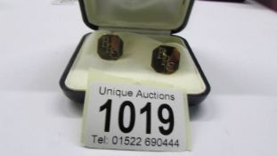A pair of gold cuff links monogrammed R P E.