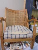 A bergere backed chair with seat that needs replacement.