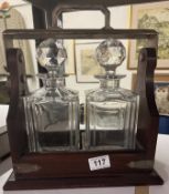 A two bottle lockable tantalus with key.