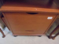 A darkwood stained office filing box with lift up top and drawer on castors.