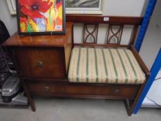 A darkwood stained classical style hall table with integral seat and drawer.