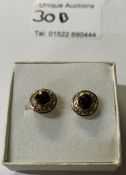 A pair of gold 9ct and garnet ear studs textured in gold mounts.