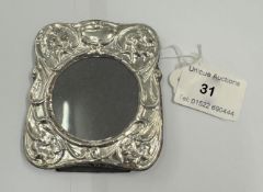 A silver easel back picture frame with embossed decoration