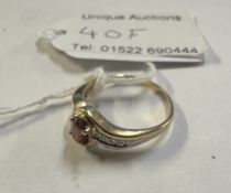 A diamond & garnet set ring oval garnet with diamond shoulders in gold