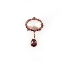 A late 18th century mother of pearl, ruby, and diamond brooch, the mother of pearl framed by