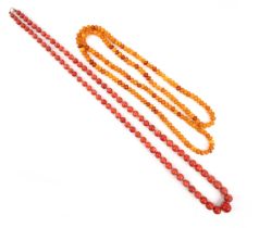 λ A coral bead necklace, the beads graduating to 14mm, length 84cm, 89g, with an amber bead
