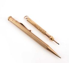 Two gold propelling pencils, comprising: one with hexagonal grip and engine-turned decoration with