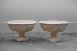 A pair of cast plaster urns,