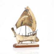 A silver presentation trophy shaped as a boat,