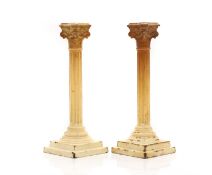 A pair of creamware Corinthian column candlesticks,