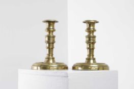 A pair of George IV brass candlesticks,
