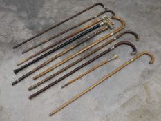 A collection of silver mounted walking sticks and canes,