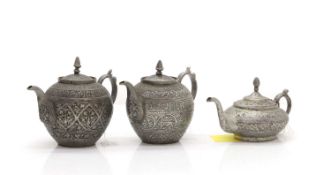 A collection of three Afghan metalware teapots,