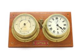 A wall-mounted clock and an aneroid barometer,