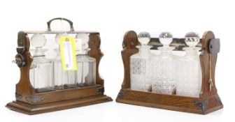 A pair of oak and silver plated three-bottle tantalus,