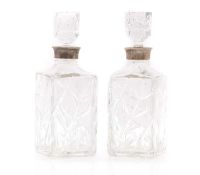 A pair of silver mounted glass whisky decanters,
