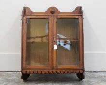A Gothic Revival walnut glazed hanging bookcase,