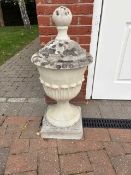 A pair of reconstituted garden urns, with integral covers,