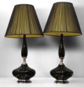 A pair of black glass and chrome table lamps,