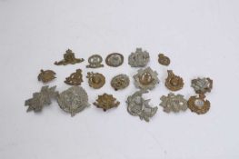 A collection of brass and metal cap badges,