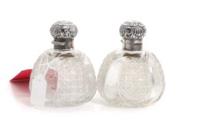 A pair of cut glass and silver collared scent bottles,