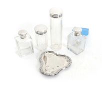 Four clear glass bottles with silver covers,