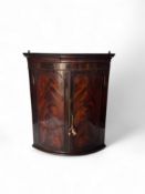A George III flamed veneered mahogany corner cupboard