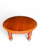 A mid Victorian mahogany extending circular dining table with two leaves